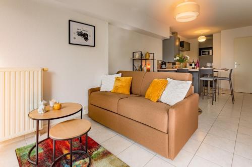 sala de estar con sofá y mesa en Appart cosy avec grand balcon et parking privatif en Lorient
