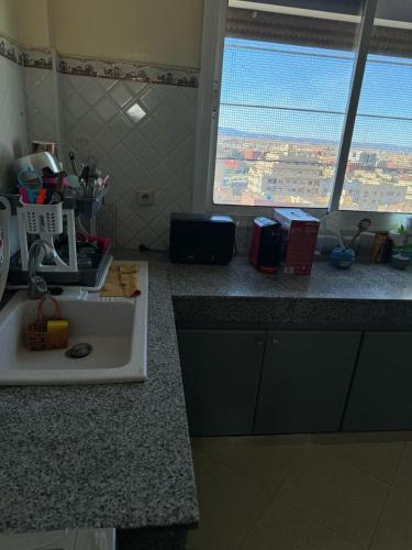 a kitchen counter with a sink and a window at Appartement Boulevard Mohammed Derfoufi, Oujda in Oujda