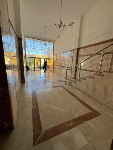 a lobby with stairs and a person walking in a building at Appartement Boulevard Mohammed Derfoufi, Oujda in Oujda