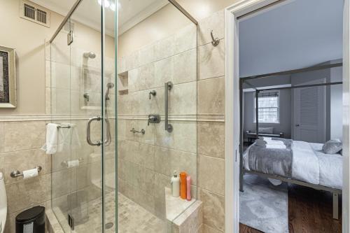 a bathroom with a glass shower and a bed at LUX Entire home in Bethesda RARE in Bethesda