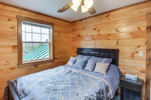 1 dormitorio con 1 cama en una habitación de madera en Pet-Friendly Houtzdale Hideaway with Gas Grill! 