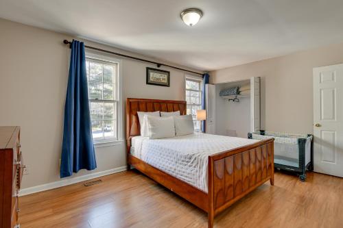 1 dormitorio con cama y cortina azul en Montgomery Village Townhome with Patio 27 Mi to DC!, en Montgomery Village