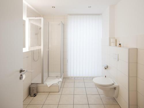 a white bathroom with a toilet and a shower at city boarding lippstadt in Lippstadt