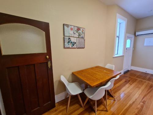 a dining room with a wooden table and white chairs at Dunedin City Centre Tidy Affordable Room A in Dunedin