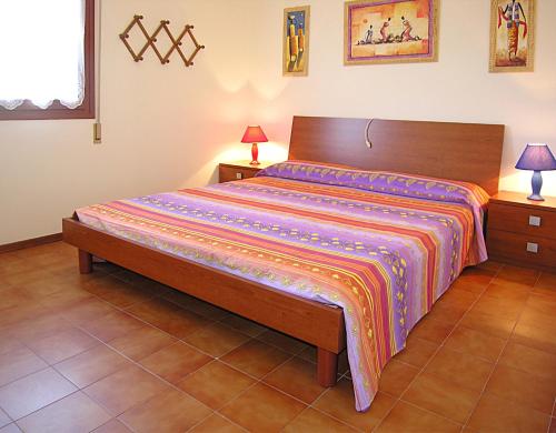 una camera da letto con un letto con una coperta colorata di Appartamenti Lira a Bibione