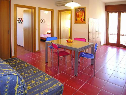 una camera con tavolo, sedie e letto di Appartamenti Lira a Bibione