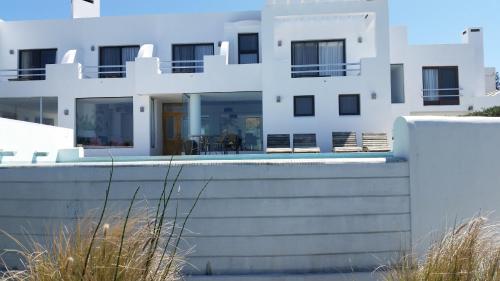 a white building with a pool in front of it at Posada de los Pajaros in Punta del Este