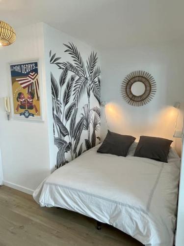 une chambre avec un grand lit blanc avec un miroir dans l'établissement Studio Côte&Plage, vue mer panoramique, à Pornichet