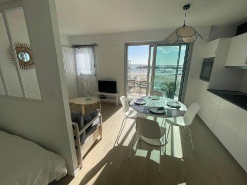 un salon avec une table et des chaises et une chambre dans l'établissement Studio Côte&Plage, vue mer panoramique, à Pornichet