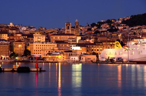 a view of a city from the water at night at Il Balcone Sul Corso in Ancona