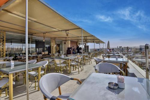 a restaurant with tables and chairs on a roof at Mamlouk Pyramids Hotel in Cairo
