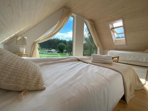 a white bed in a room with a window at Stodoła Drwęck in Drwęck