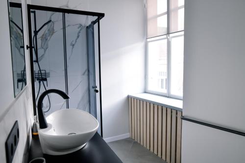 a bathroom with a white sink and a window at BESLEV in Tallinn