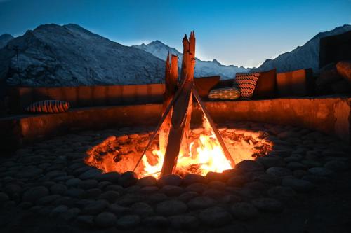 un foyer extérieur au milieu d'une montagne dans l'établissement Razhek, à Karimabad Hunza