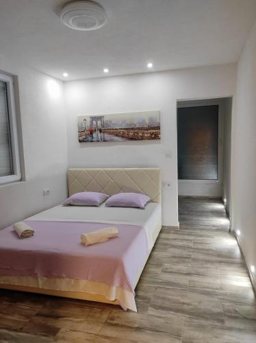 a bedroom with a large bed with purple pillows at Vila Ideal in Donji Štoj