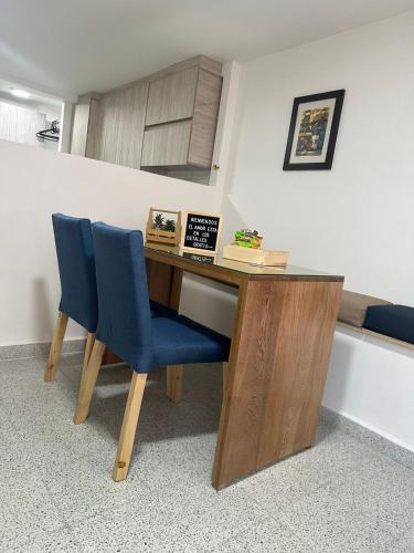 a desk with a blue chair in a room at loft cerca a laureles, WIFI, cerca metro y GUARDA EQUIPAJE GRATIS!! in Medellín