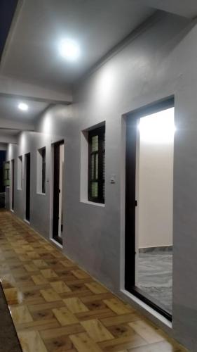 um corredor com paredes brancas e piso de madeira em Arasu Homestay em Antarasante