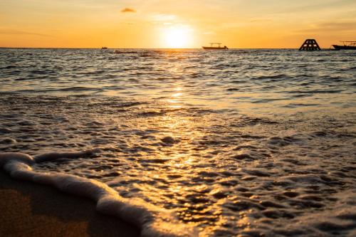 a sunset on a beach with the ocean at Blue Lagoon Beach Resort in Nacula Island