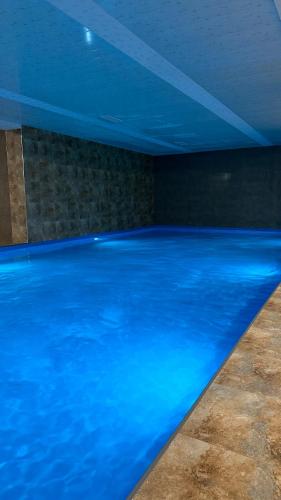 a large swimming pool with blue water in a room at Tsaghkadzor Alvina Complex 12 Project in Tsaghkadzor