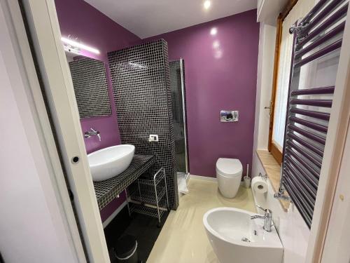 een paarse badkamer met een wastafel en een toilet bij B&B Elia's in Cagliari