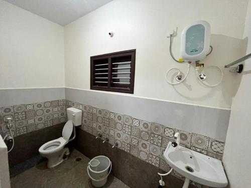 a bathroom with a sink and a toilet and a window at Arasu Homestay in Antarasante