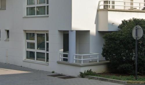 ein weißes Gebäude mit einem Balkon an der Seite in der Unterkunft Bail mobilité Le Grimaldi in Massy