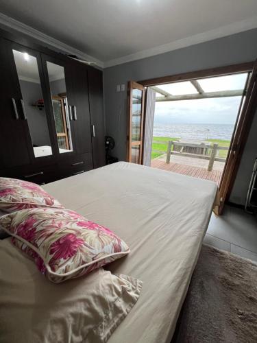 1 dormitorio con 1 cama y vistas al océano en Quiosque beira da lagoa, en Terra de Areia