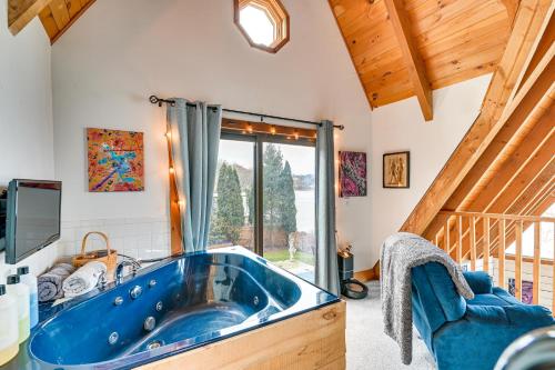 a large blue tub in a room with a window at Riverfront A-Frame Cabin in Troy with Pool and Dock! in Troy