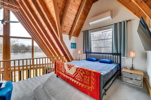 a bedroom with a bed and a balcony at Riverfront A-Frame Cabin in Troy with Pool and Dock! in Troy