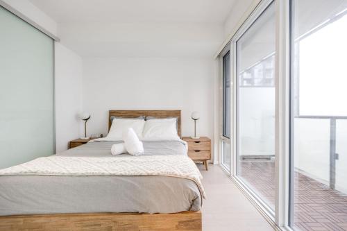 a bedroom with a bed and a large window at Downtown Charm 2BR Retreat in Prime Location in Toronto