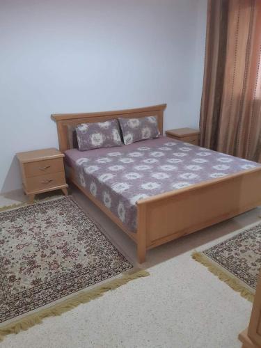 a bedroom with a bed and two rugs in a room at Logement entier : appartement s2 Gabès in Gabès