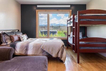 ein Schlafzimmer mit einem Etagenbett und einem Fenster in der Unterkunft Teton Crest Lodge Sleeps 24 Ideal Reunion Spot in Driggs