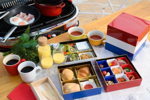 a table topped with food and drinks and a box of food at ファームグランピング　ル・クロ　かいづか　いぶきヴィレッジ in Kaizuka