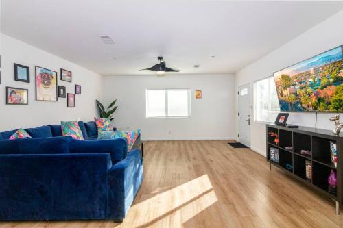 a living room with a blue couch and a tv at Colorful Home 3Bd 2Ba, Sleeps8, 1block to Univ., Pac-man, BBQ, FirePit in Redlands