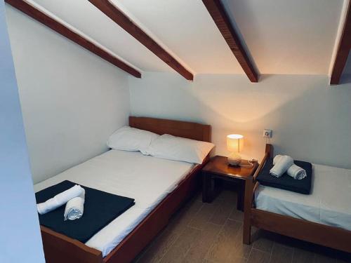 a bedroom with two beds and a table with a lamp at ofrynio kavalas Martin House in Karianí