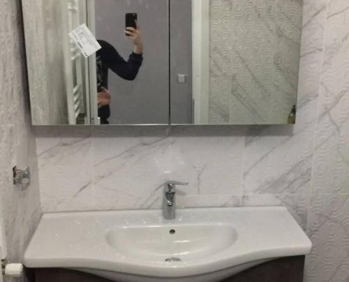une personne prenant une photo d'un lavabo dans une salle de bains dans l'établissement halit ev 2, à Istanbul