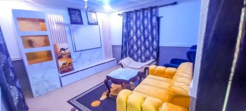a living room with a yellow couch and a window at CRE8 Homes in Tamale