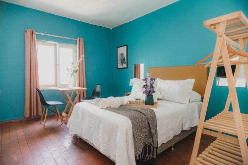 ein Schlafzimmer mit einem Bett und einer blauen Wand in der Unterkunft Miraflores Private Rooms - Guest House - Cocina Compartida - Terraza in Lima