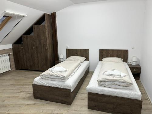 two twin beds in a room with a attic at Samadhi Aparthotel in Miercurea-Ciuc