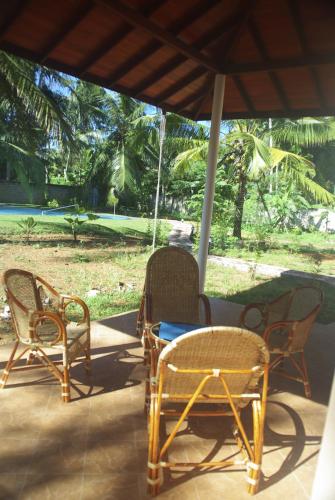 a group of chairs and a table on a porch at King Coconut Lodge in Habaraduwa Central