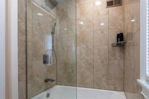 a bathroom with a shower with a bath tub at Home Away From Home on LaSalle - 3 bd 2 bth Slps 6 in Niagara Falls