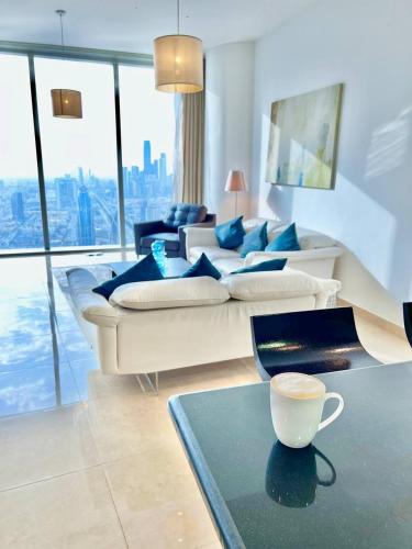 una sala de estar con sofá y una taza de café sobre una mesa. en Goatskynest Riyadh skyline view suites en Riad