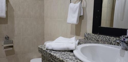 bagno con lavandino, servizi igienici e lavandino bianco di Gran Hotel CCP Suites a Maturín