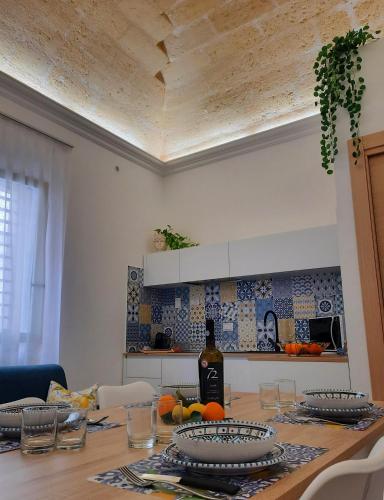 a kitchen with a table with a bottle of wine at Il Canto Di Iside in Marsala