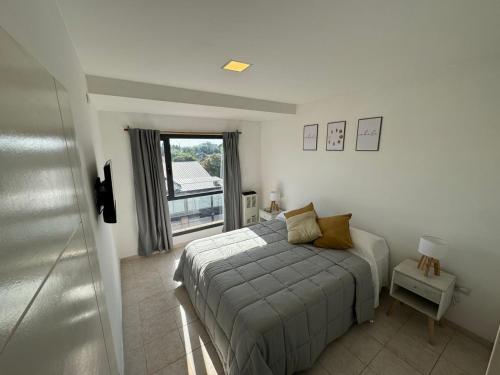 um quarto com uma cama e uma janela em Solar Suites em Neuquén
