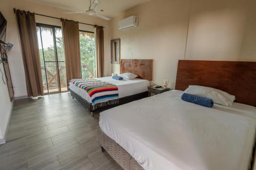 a hotel room with two beds and a window at Casa Delfín Tulum in Macario Gomez