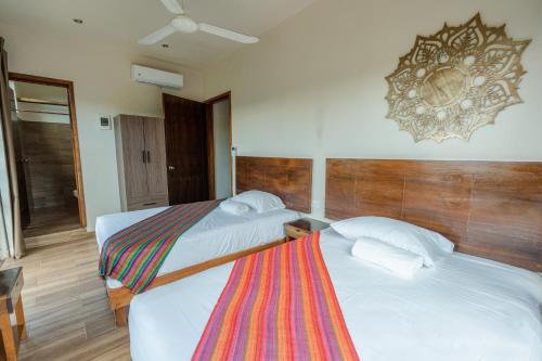 a hotel room with two beds and a mirror on the wall at Casa Delfín Tulum in Macario Gomez