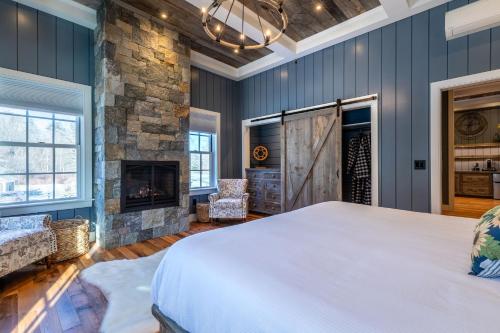 a bedroom with a large bed and a fireplace at The Barnstead Inn in Manchester Center