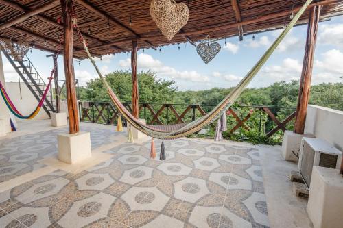 a patio with a hammock and a view at Casa Delfín Tulum in Macario Gomez