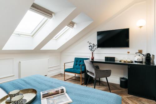 a room with a bed and a desk and a tv at Central Palace - LoftAffair Collection in Kraków